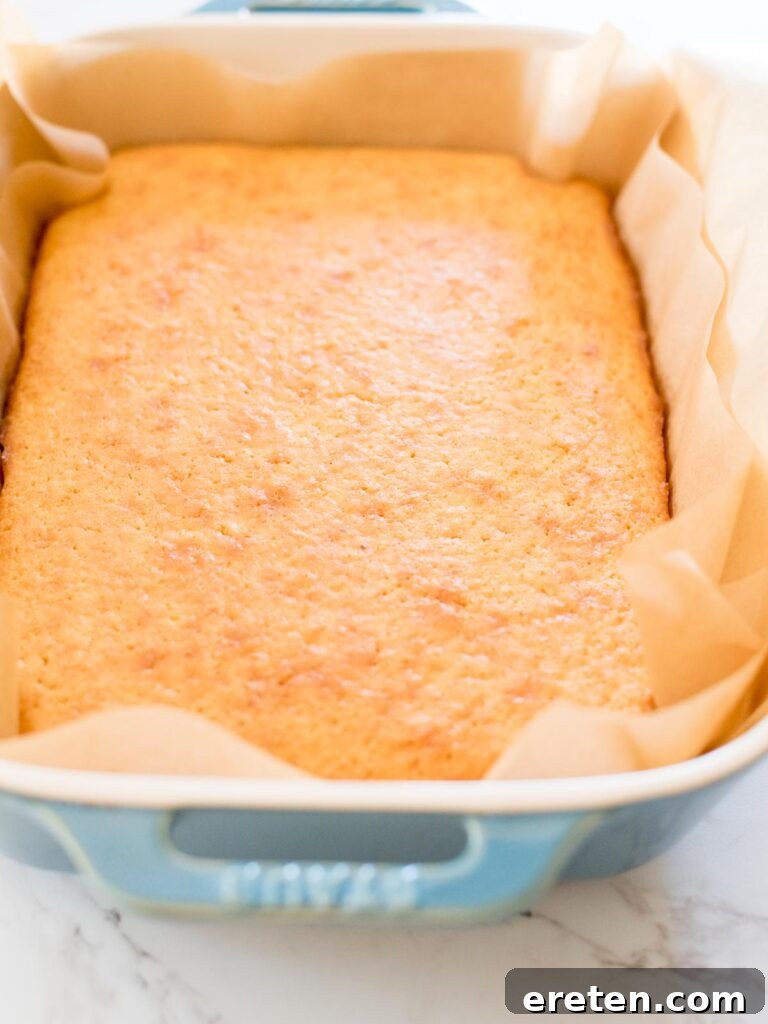 A freshly baked cornbread loaf still in its baking dish, radiating warmth