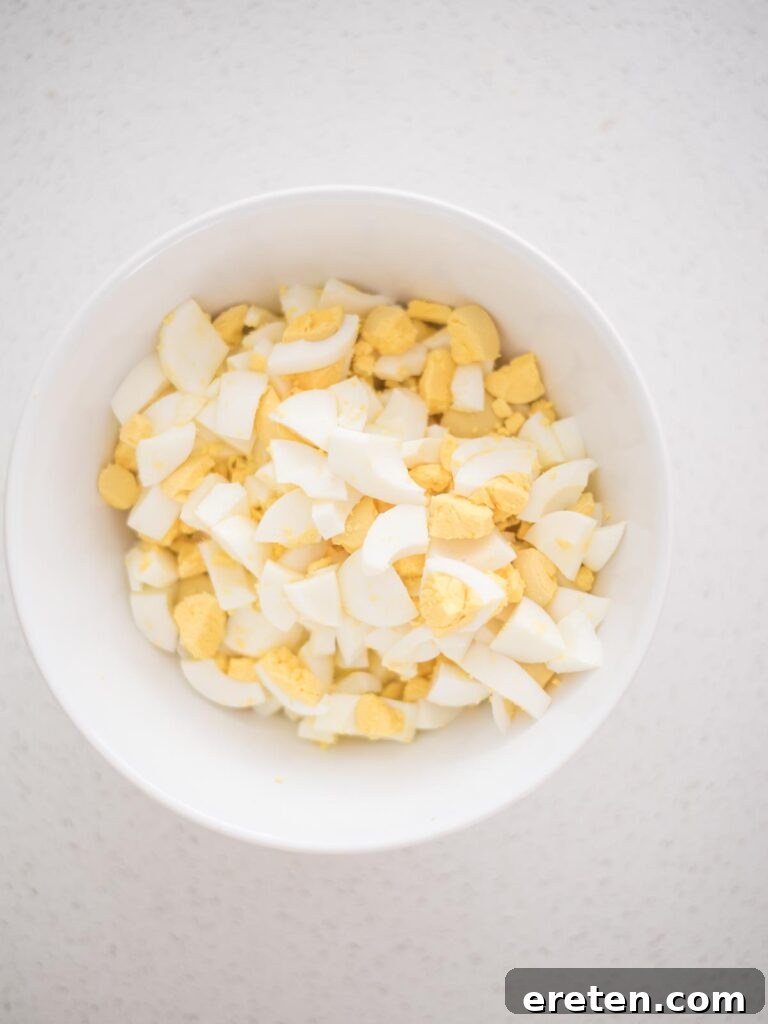 Dill-icious Egg Salad: Perfect for Quick Wraps and Elegant Tea Sandwiches 4 Chopped hard-boiled eggs in a mixing bowl, ready for the dressing to be added for an easy egg salad recipe