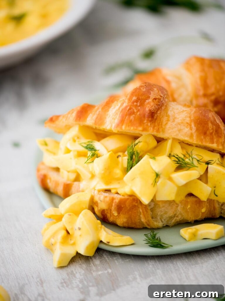 Dill-icious Egg Salad: Perfect for Quick Wraps and Elegant Tea Sandwiches 10 Creamy easy egg salad served on a flaky croissant, garnished with fresh dill sprigs