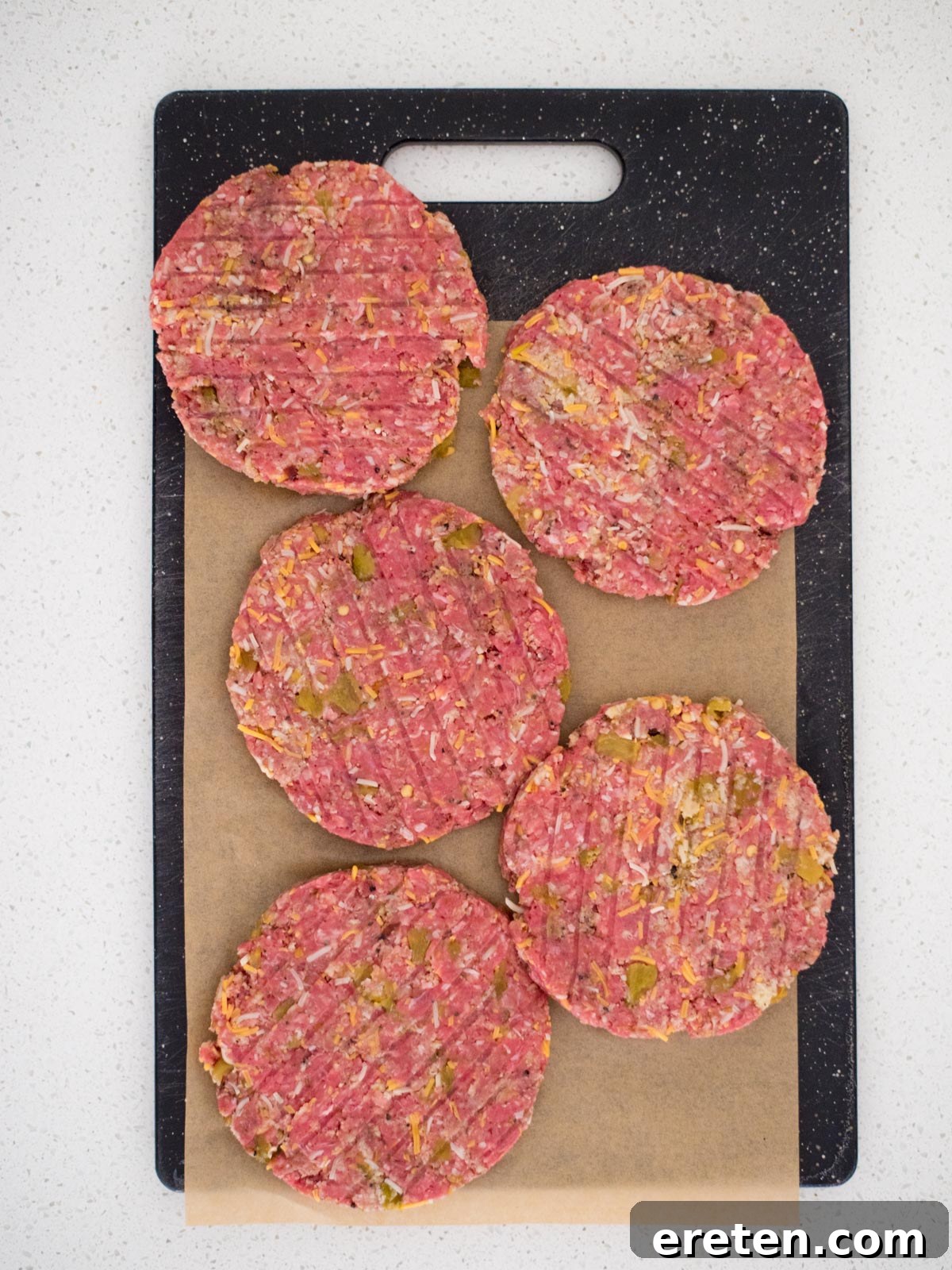 smoked burger patties on a cutting board with parchment paper