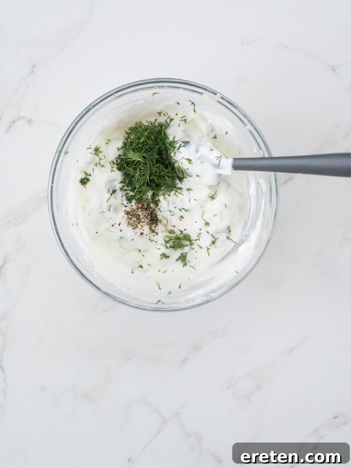 dill, pepper, and salt added to greek yogurt for tzatziki
