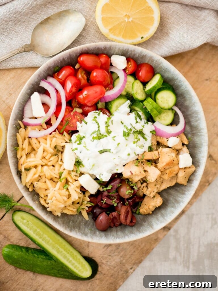 Greek Chicken Bowl topped with creamy tzatziki, fresh cucumbers, and fragrant dill