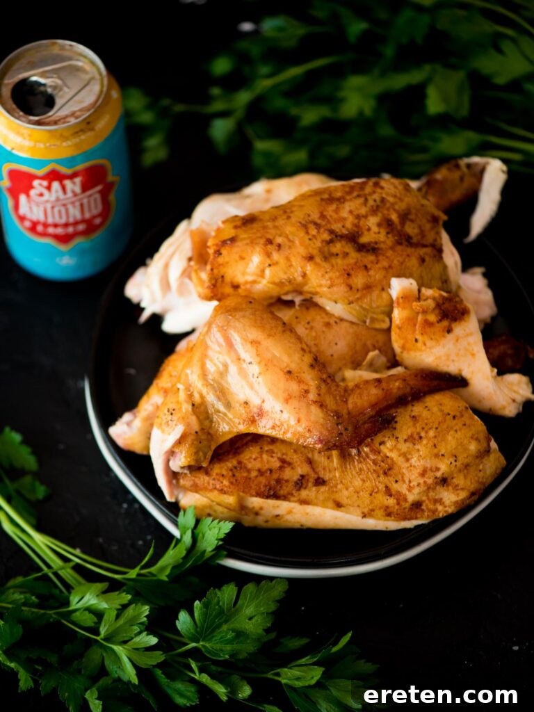 Pint-Infused Smoked Chicken Feast 7 pit boss beer can chicken on a plate surrounded by parsley