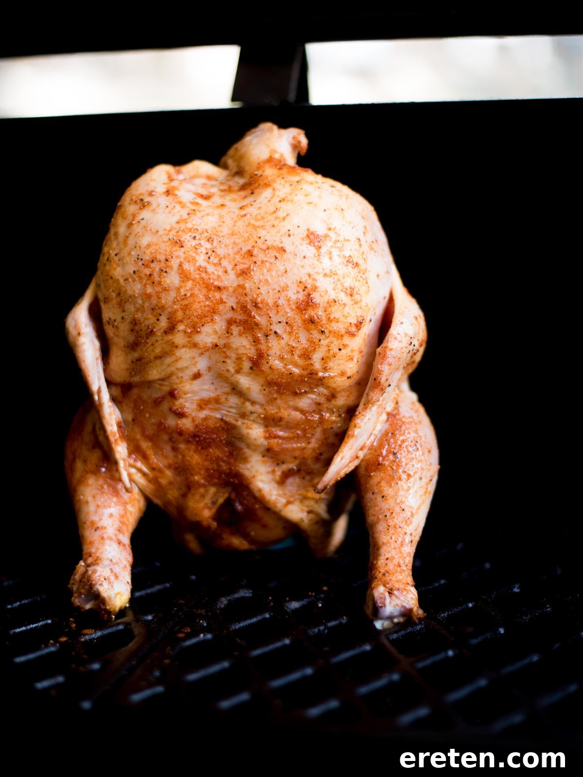 Pint-Infused Smoked Chicken Feast 5 raw seasoned beer can chicken on a pellet grill standing up on a beer