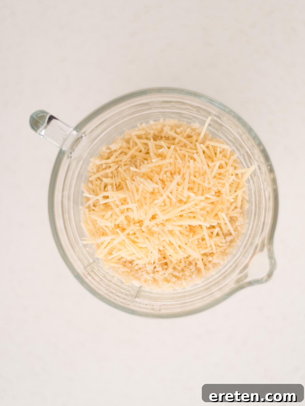 Next-Level Smoked Macaroni 15 grated parmesan added to the buttered breadcrumbs in a measuring cup