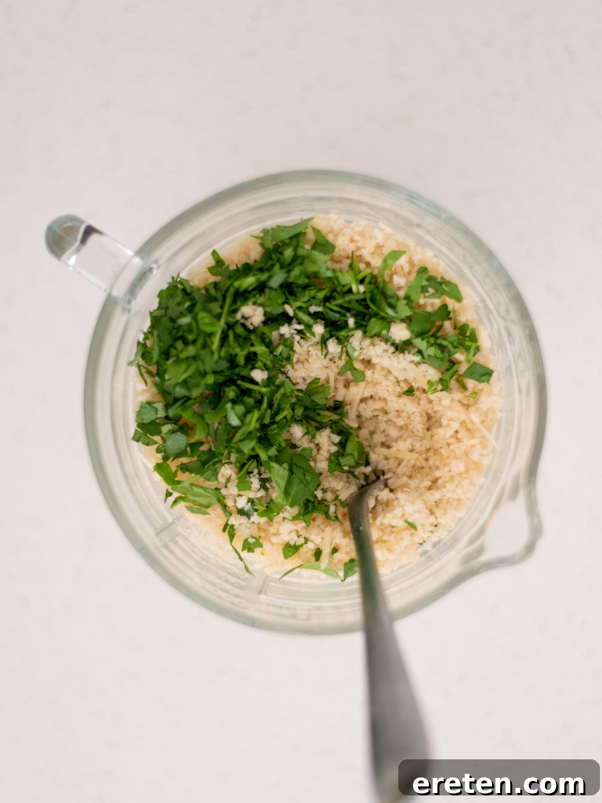 Next-Level Smoked Macaroni 16 parsley added to the measuring cup with breadcrumbs, butter, and parmesan