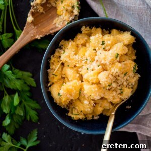 smoked macaroni and cheese in a blue bowl surrounded by parsley and a large spoon