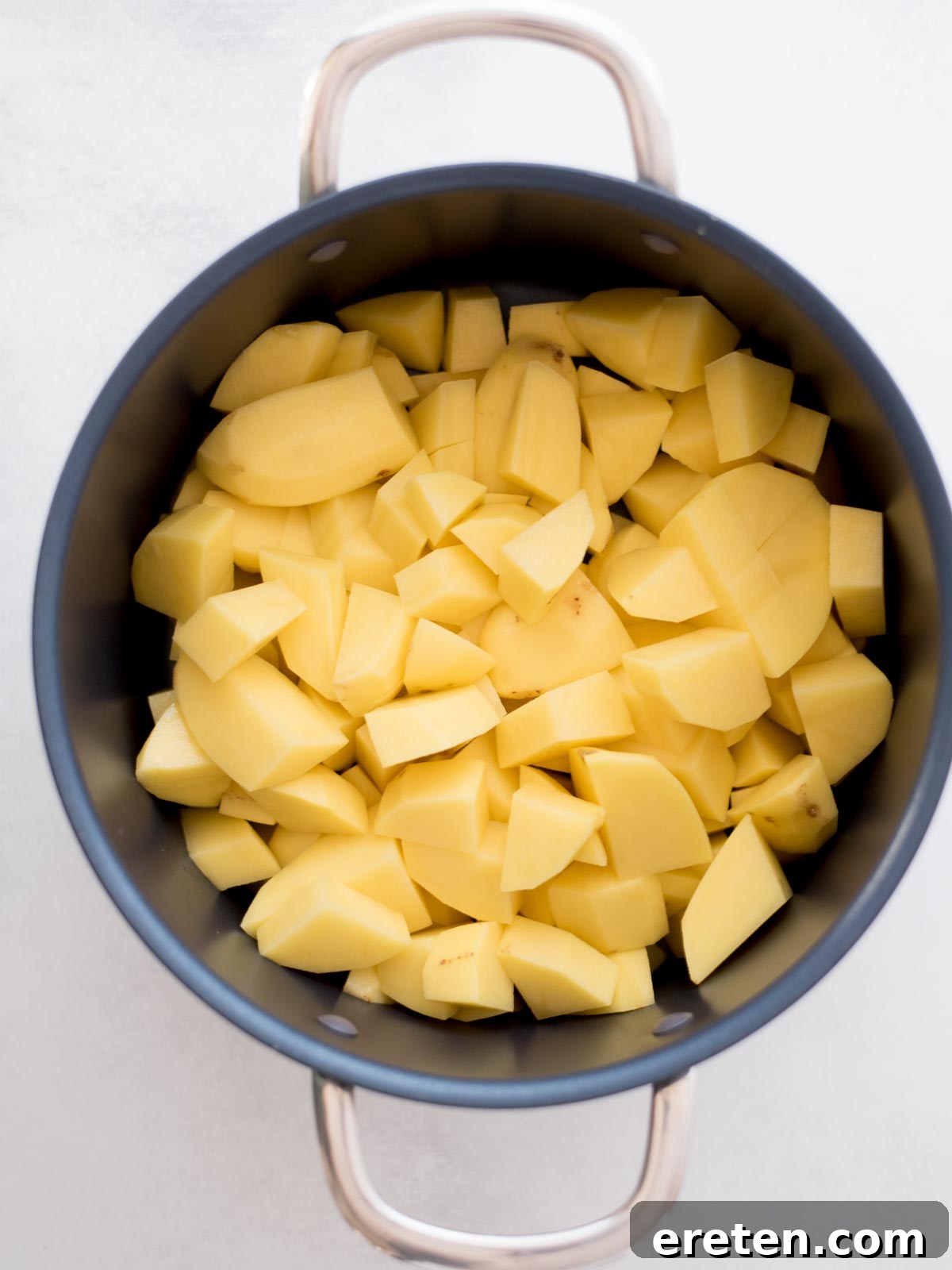 Peeled and chopped potatoes added to a large pot.