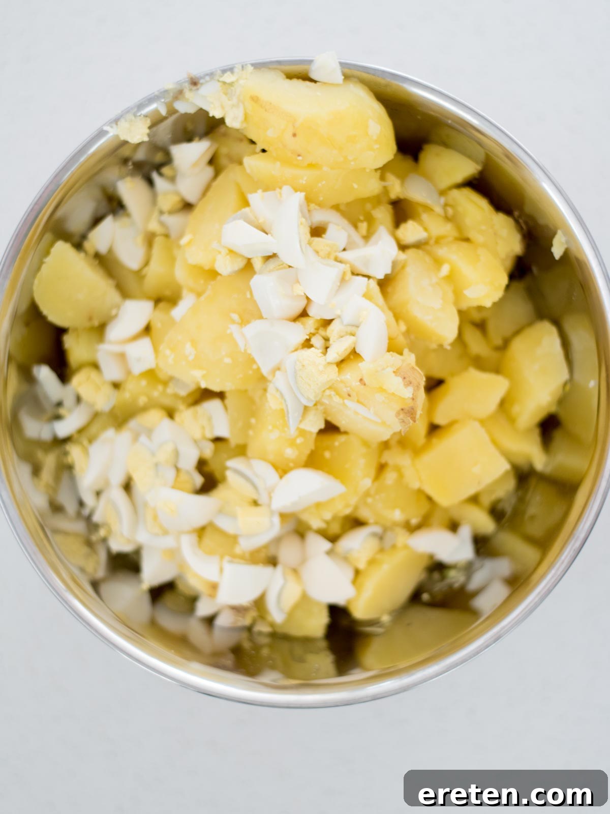 all ingredients of potato salad in a mixing bowl before mixing