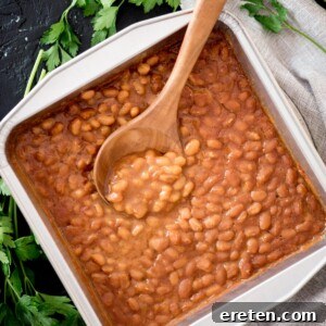 smoked baked beans in a baking dish with a spoon