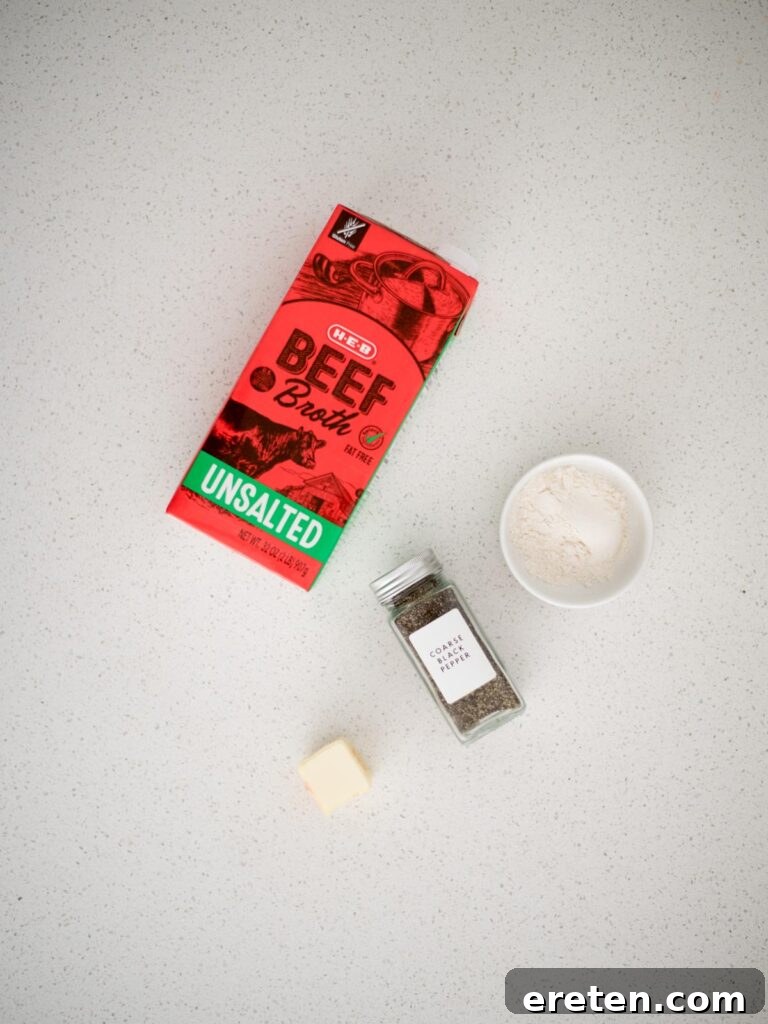 Hearty Southern Brown Gravy 3 Collection of simple ingredients laid out on a countertop, ready to be used for making homemade brown gravy, including beef broth, butter, and flour.