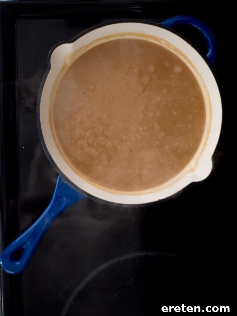 Hearty Southern Brown Gravy 8 Rich, homemade brown gravy gently simmering in a skillet on the stovetop, achieving a perfect, thick consistency.