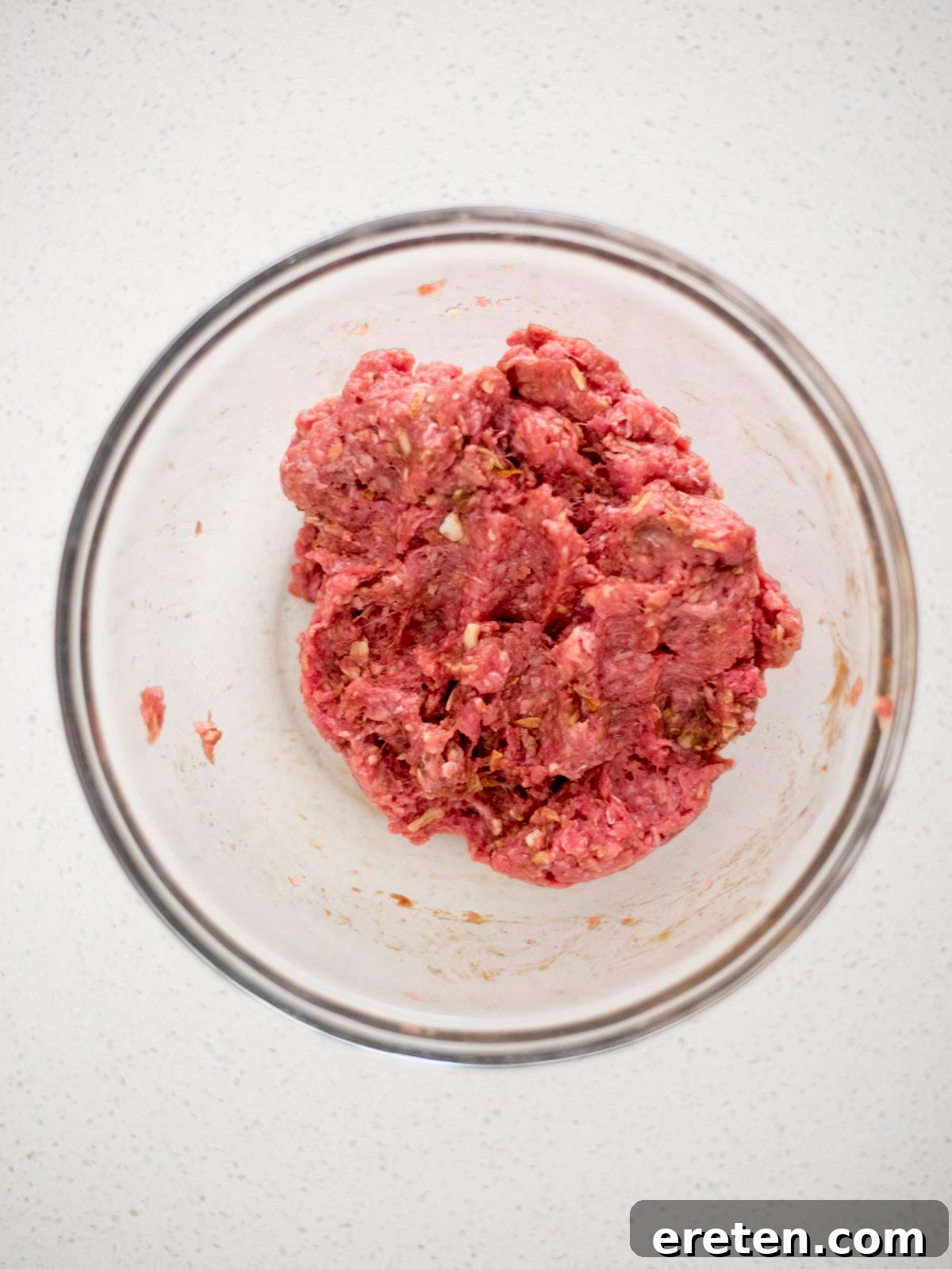 close-up view of meatball ingredients being mixed together in a large bowl, demonstrating the combining process