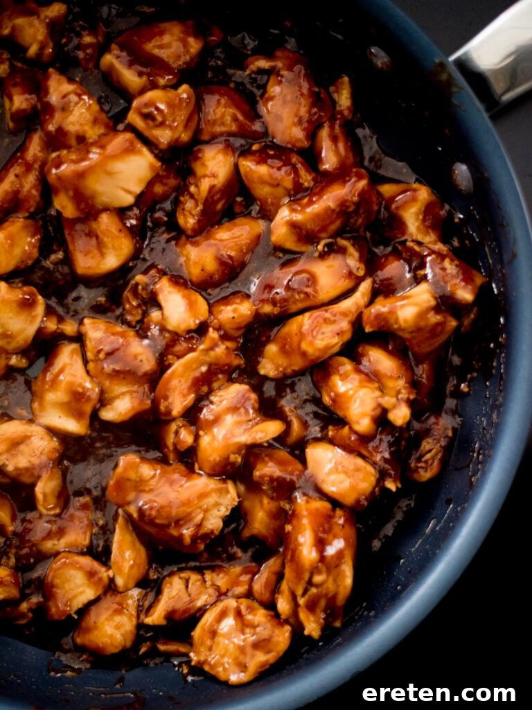 Close up view of succulent chicken breast chunks, perfectly cooked and glazed in the rich General Tso sauce.