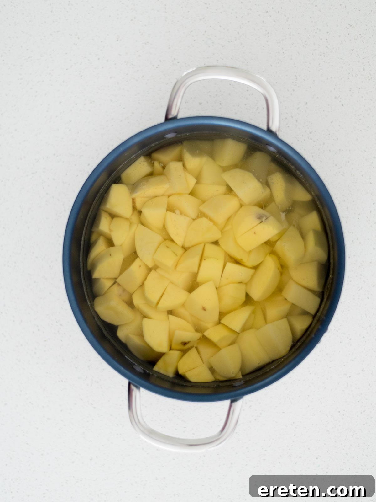 Raw potatoes added to a sauce pan covered with water.