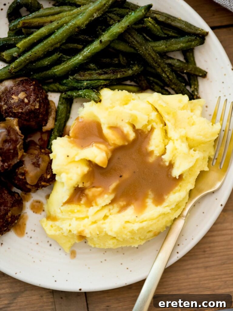brown gravy served over yukon gold mashed potatoes with meatballs and roasted green beans