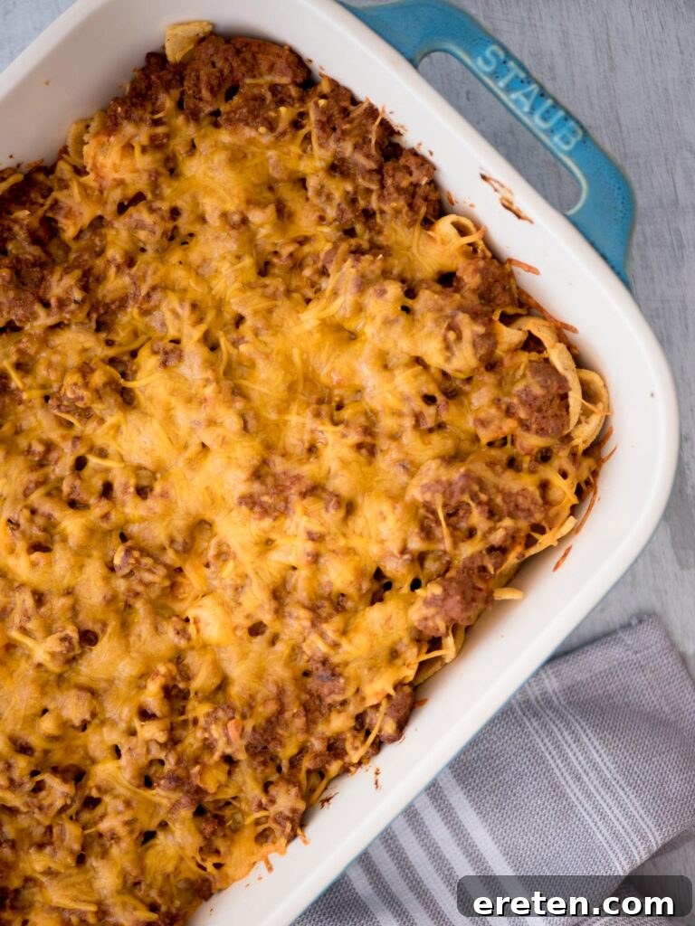 A bird's eye view of a golden-brown Walking Taco Casserole in a baking dish, fresh from the oven and ready to be served.