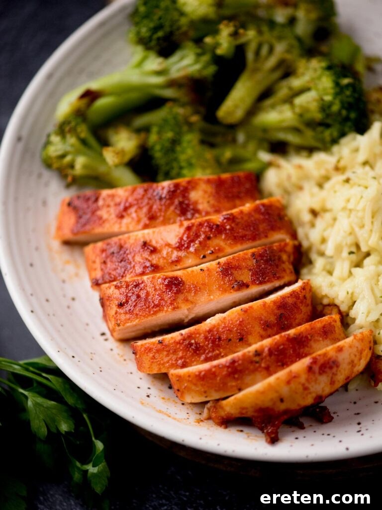 Flavorful Smoked Chicken Breast from Your Pellet Grill 2 Slices of perfectly smoked chicken breast arranged on a plate with fresh herbs.