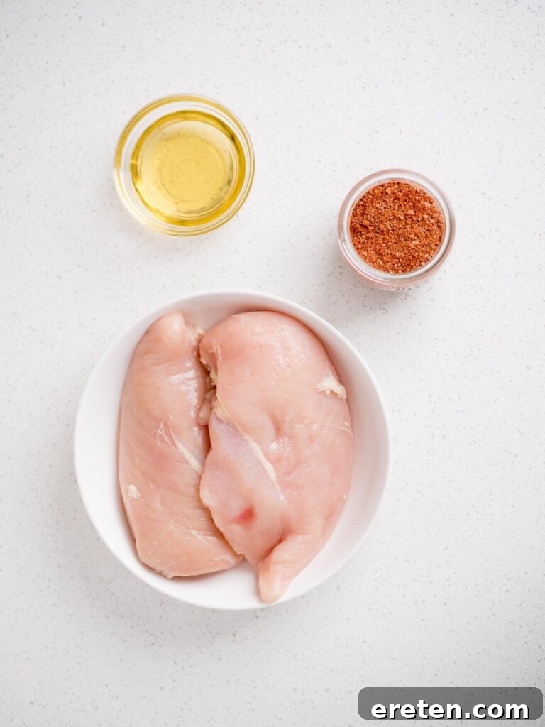 Flavorful Smoked Chicken Breast from Your Pellet Grill 3 A selection of fresh ingredients, including boneless skinless chicken breasts and various spices, laid out on a wooden board.