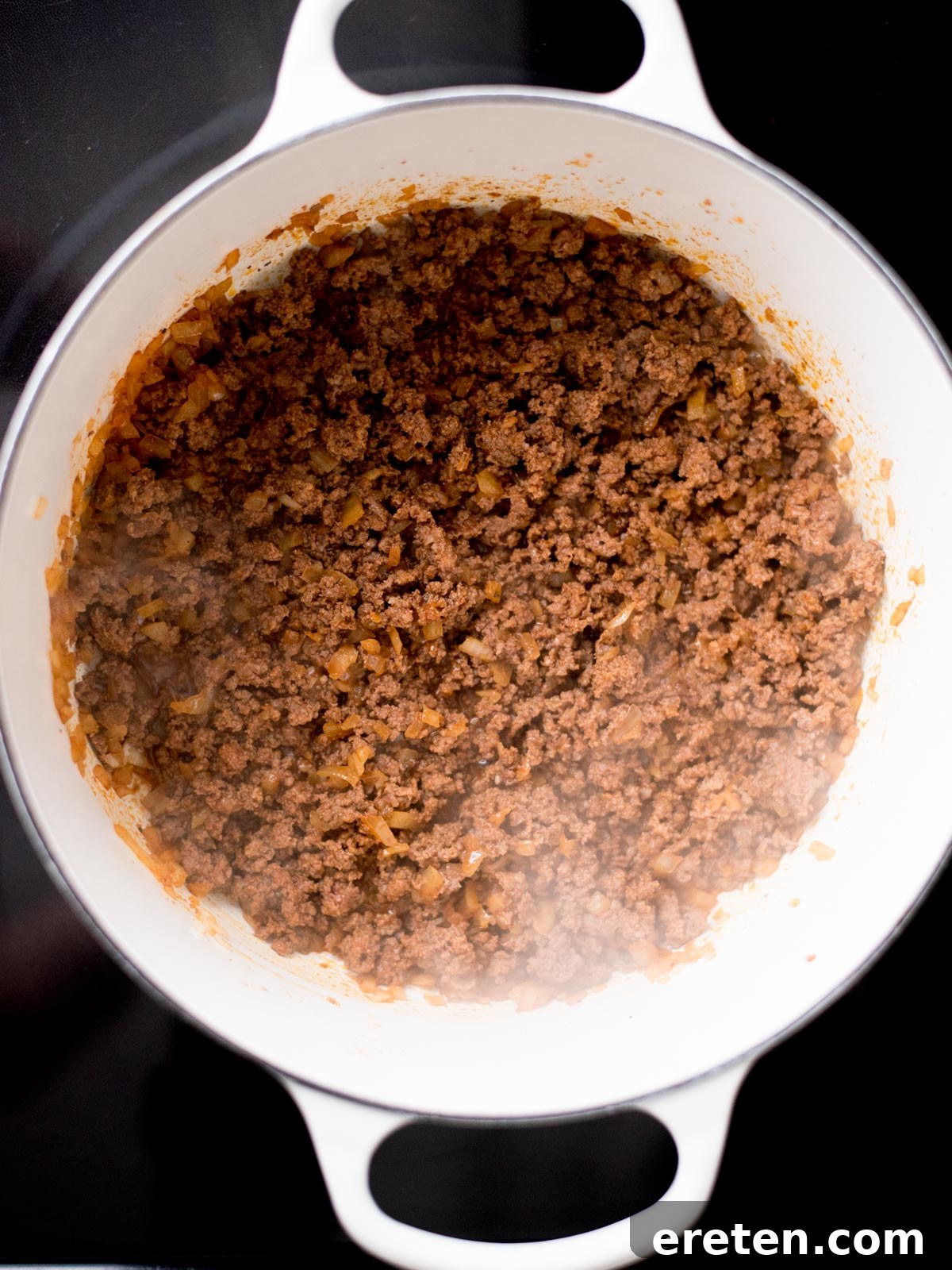 Ground beef and onions thoroughly cooked and crumbled in a dutch oven.