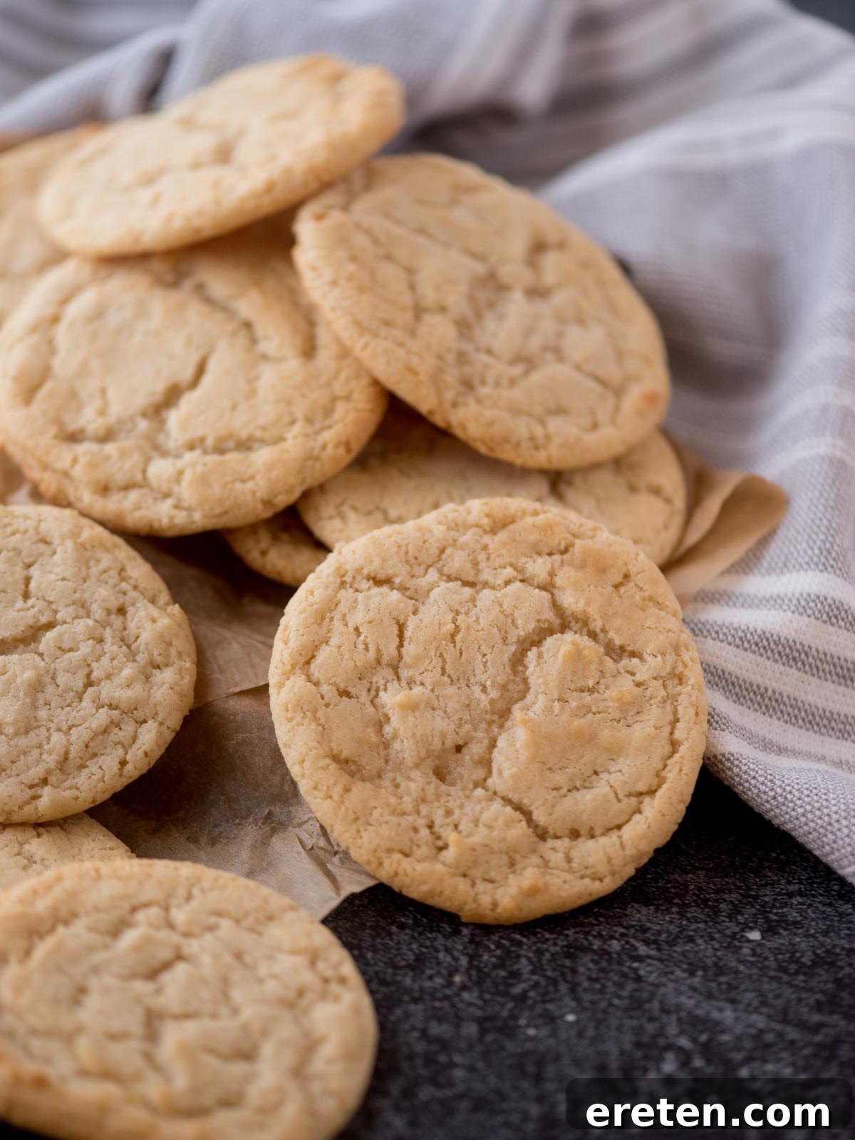 Stack of golden-brown condensed milk cookies on a rustic background, highlighting their soft texture
