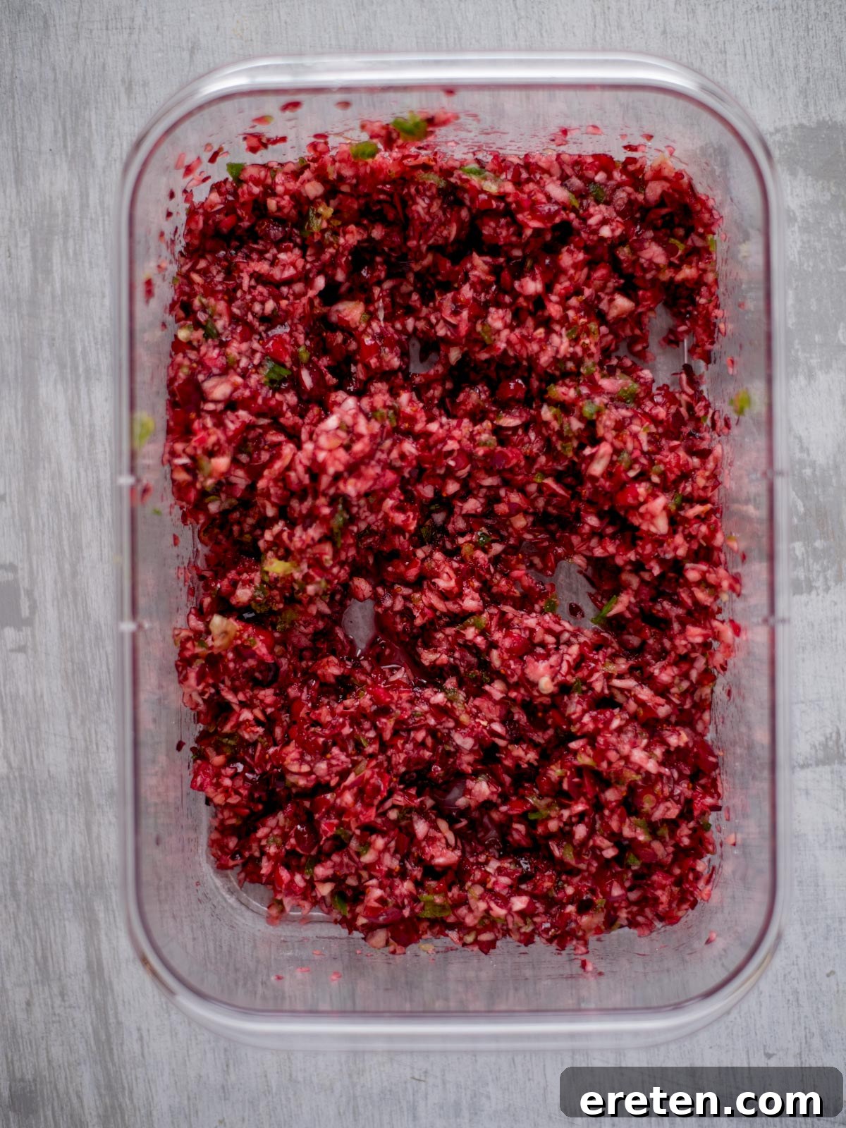 Sweet Heat Cranberry Jalapeño Dip 6 Finely diced cranberries, green onions, and jalapeños mixed in a glass dish.