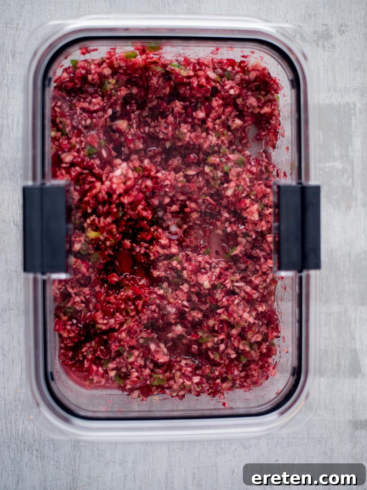 Sweet Heat Cranberry Jalapeño Dip 7 Cranberry jalapeño salsa mixture stored in an airtight container, ready for chilling.