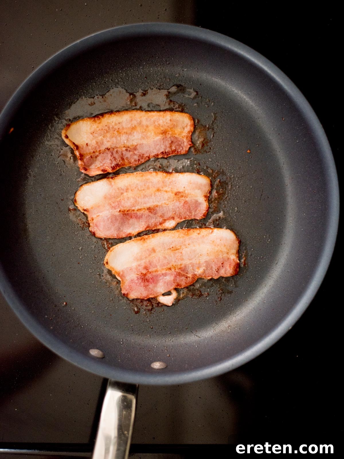 Bacon frying in a pan.