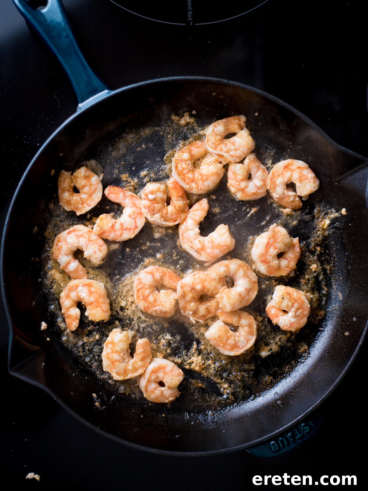 Cajun Fire Skillet with Shrimp and Sausage 4 Shrimp cooking in a cast iron pan with avocado oil.