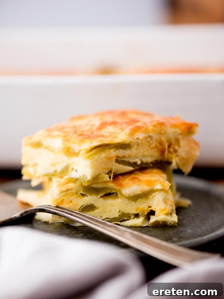 Two pieces of hatch chile relleno casserole served on a plate, showcasing its golden-brown top and cheesy interior.