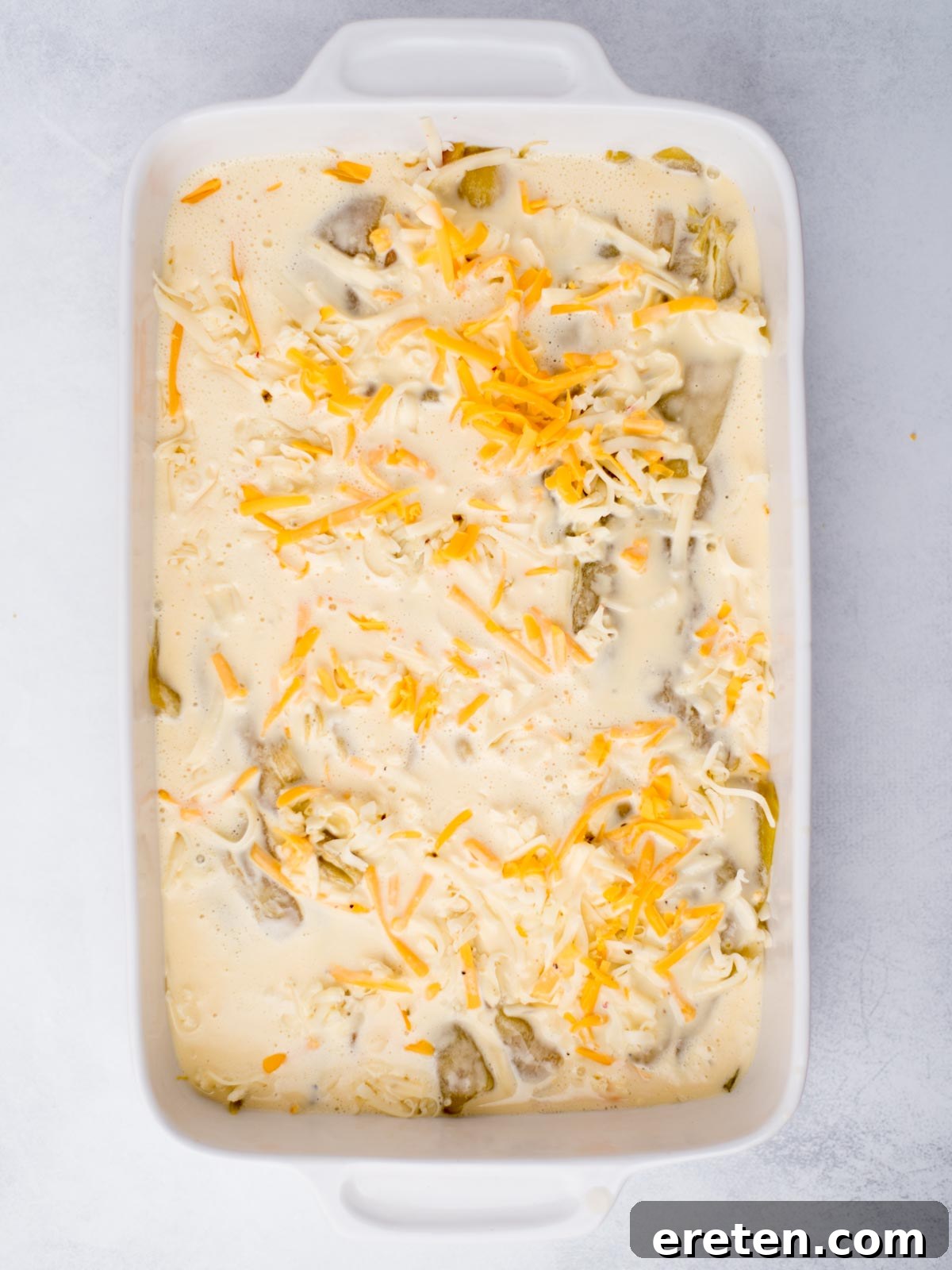 Egg mixture coating the hatch chile casserole ingredients, preparing it for baking.
