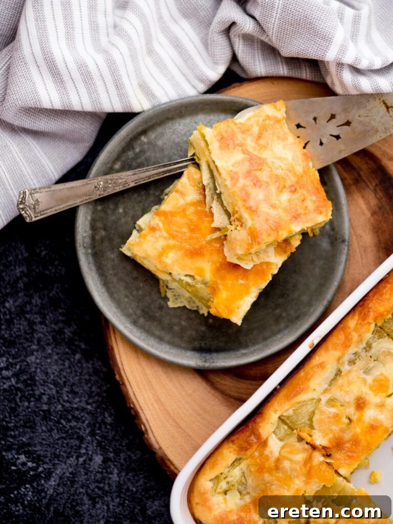 Slices of Hatch Chile Relleno Casserole on a plate next to the baking dish, showing its layered goodness.