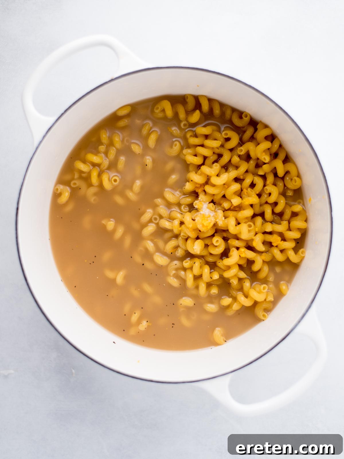 Dutch oven filled with uncooked pasta, lemon juice, seasonings and broth.