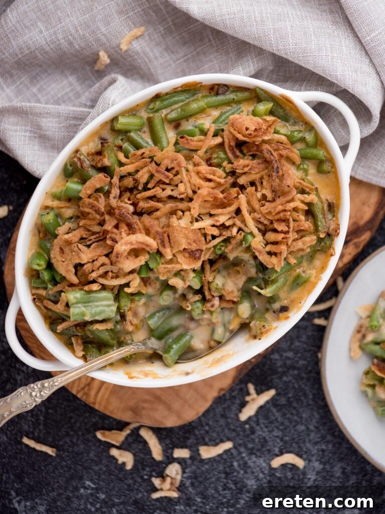 Spoon tucked into the white baking dish of green bean casserole.