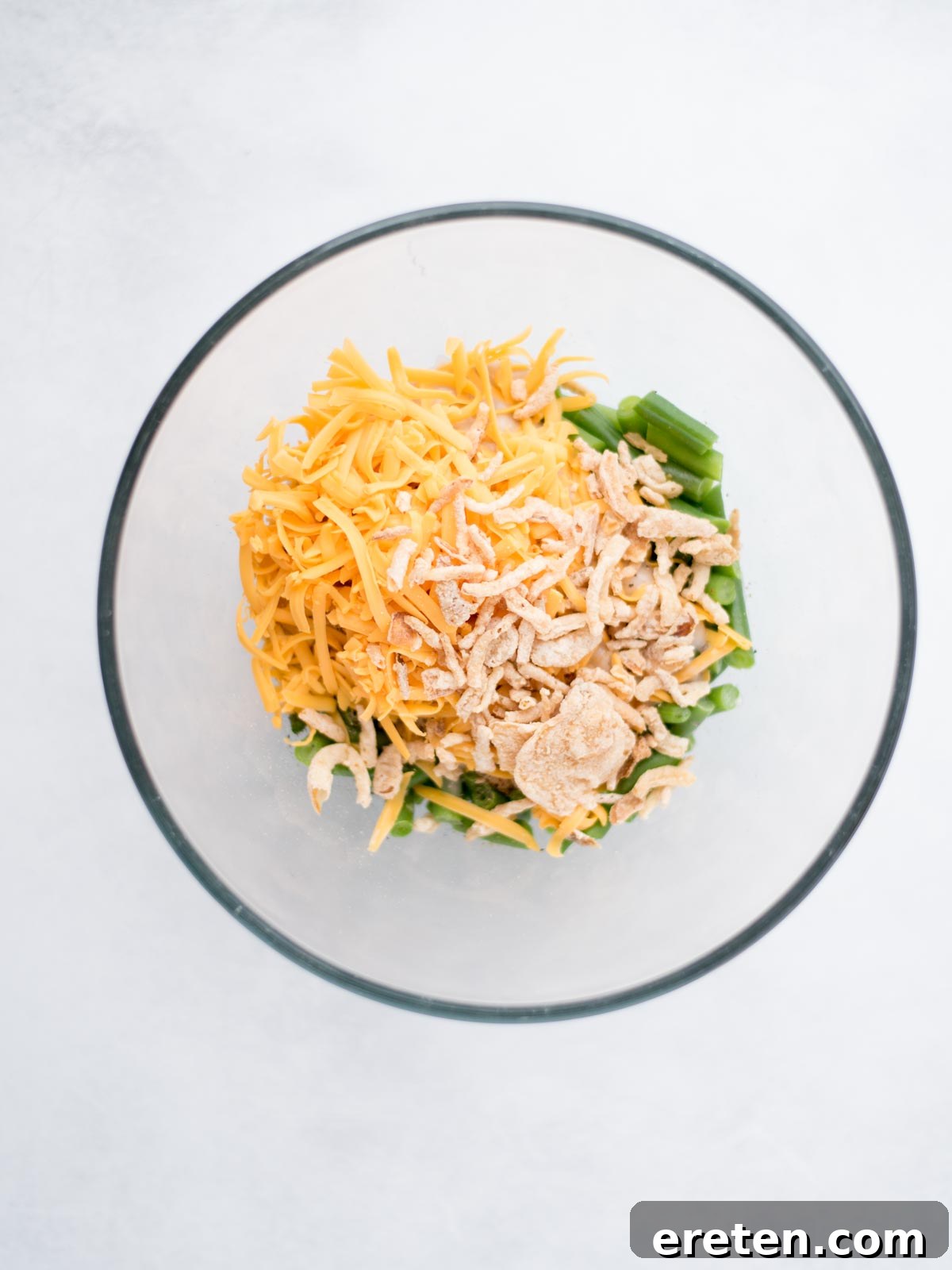 Mixing bowl filled with ingredients to make green bean casserole.