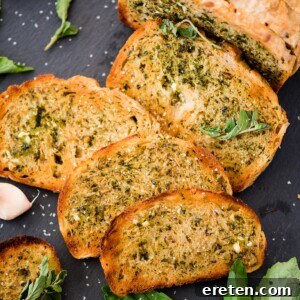 Slices of easy garlic bread on a wooden board, garnished with fresh parsley.
