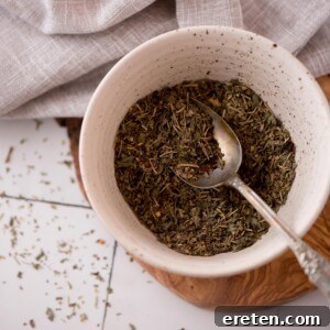 Spoon laying in a bowl of homemade italian seasoning.