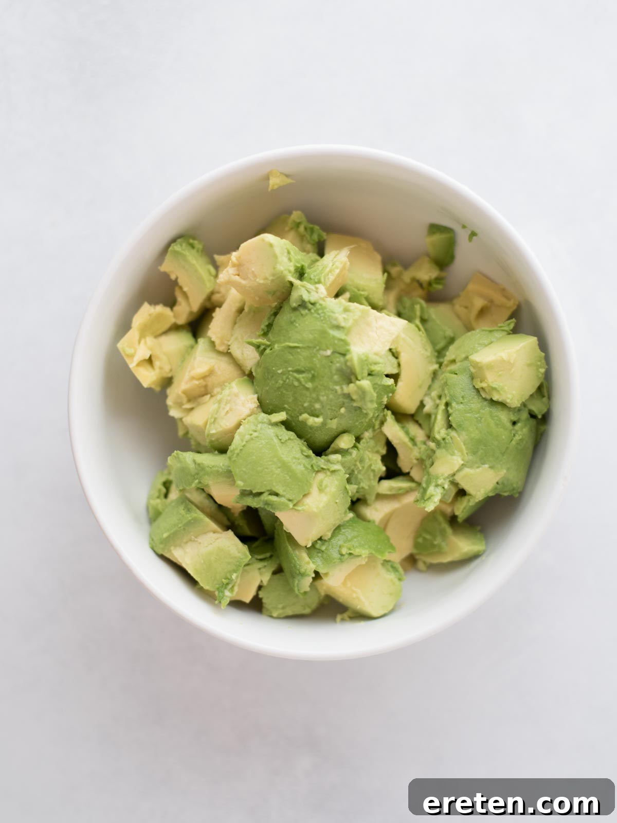 A bowl filled with freshly chopped avocado pieces, ready for mashing and seasoning.