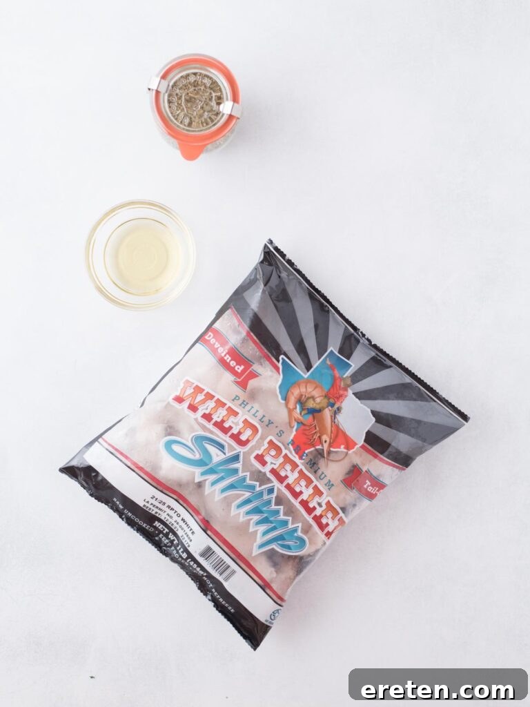 Crispy Air Fryer Frozen Shrimp 3 A vibrant selection of ingredients, including frozen shrimp, oil, and various seasonings, laid out for making air fryer frozen shrimp.