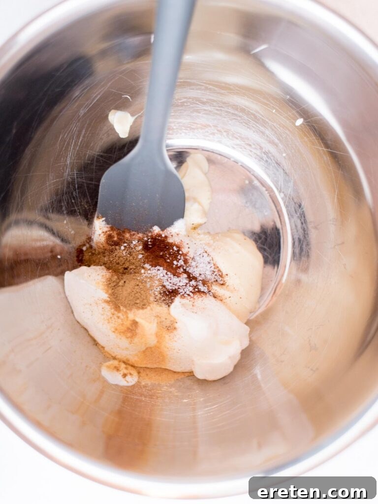 Fiesta Corn Bake 4 Seasonings being measured into a mixing bowl with mayonnaise and sour cream.