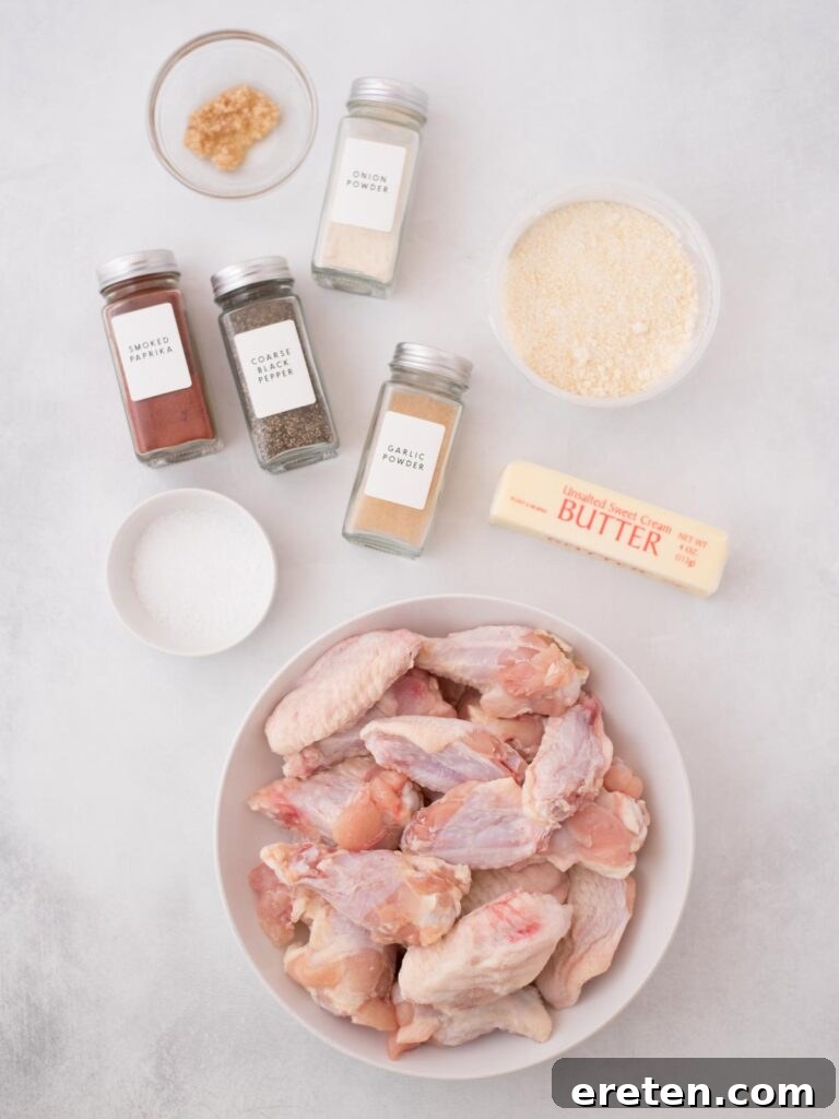 Air-Fried Golden Garlic Parmesan Wings 3 Ingredients laid out for making garlic parmesan chicken wings, including chicken wings, spices, butter, garlic, and parmesan cheese