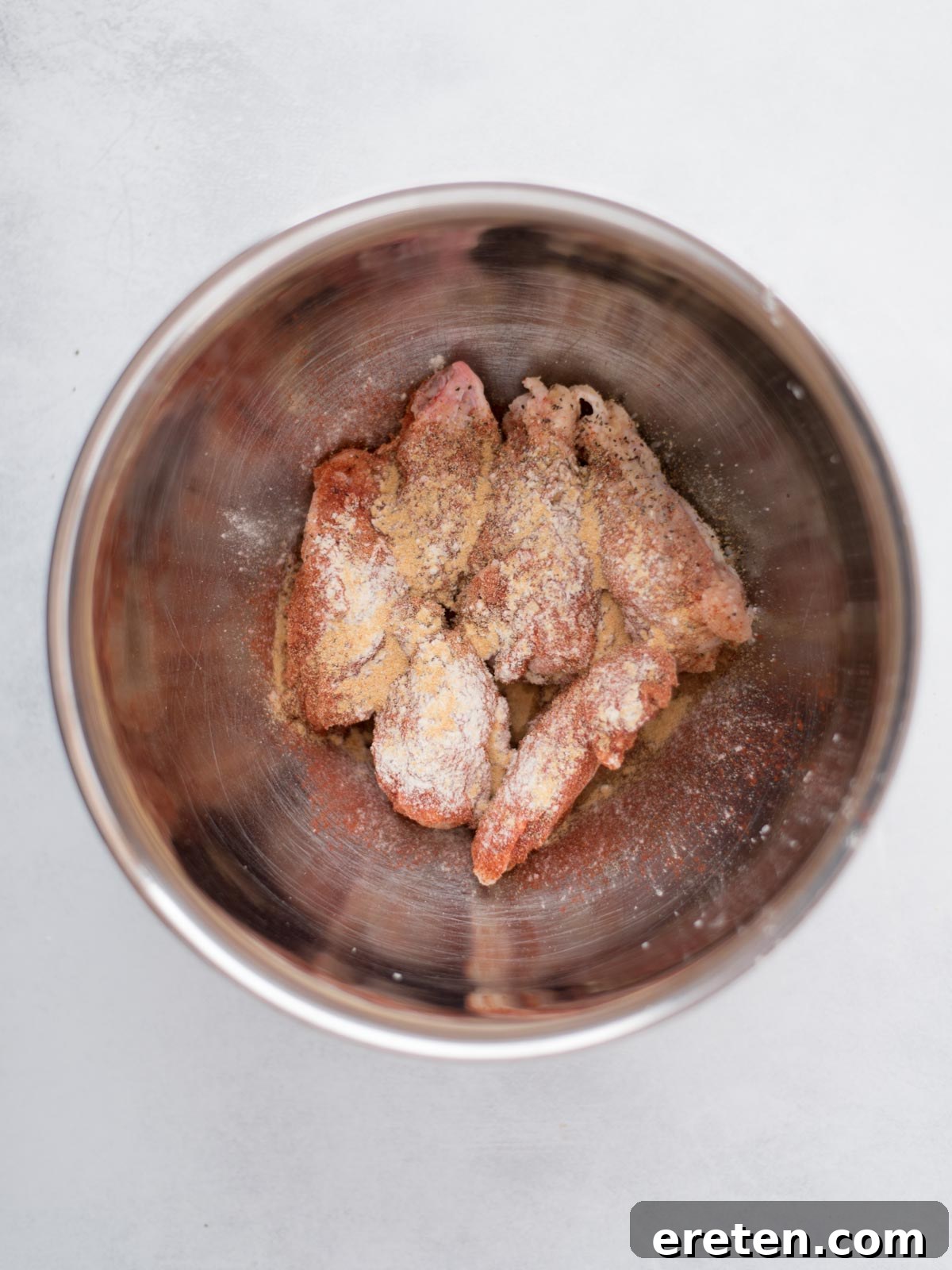 Air-Fried Golden Garlic Parmesan Wings 4 Chicken wings in a bowl seasoned with salt, pepper, garlic powder, onion powder, and paprika, ready for the air fryer