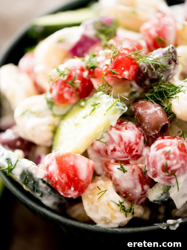 Mediterranean Tortellini Pasta Salad 11 A close-up of the Greek pasta salad with tortellini in a white bowl, garnished with fresh dill.