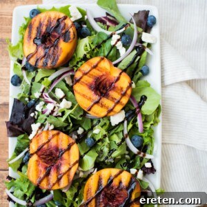 Grilled peach salad on a white plate, close-up