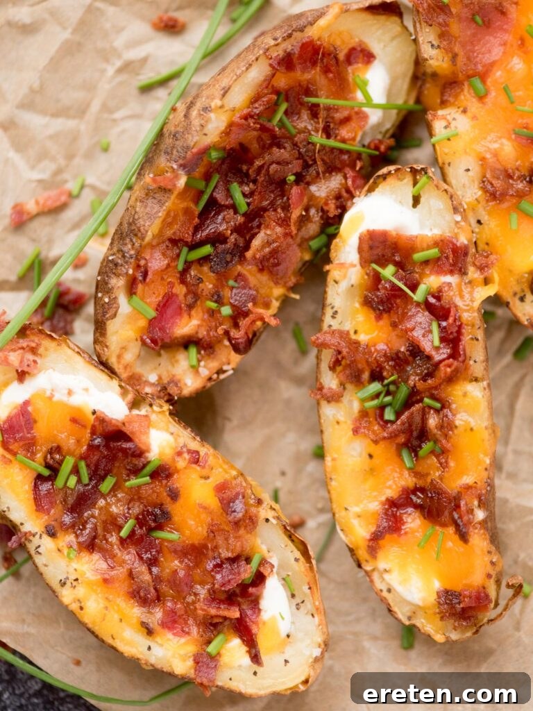 Cheese, bacon and chive loaded potato skins on parchment paper ready to enjoy.
