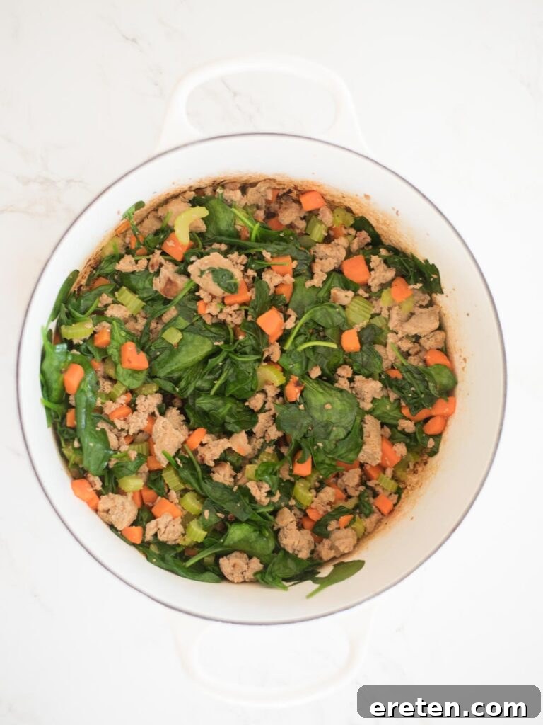meat and vegetables sautéed in a dutch oven with spinach for tortellini soup