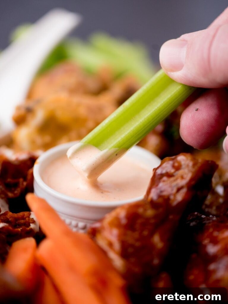 Bold Ranch Kick 2 A celery stick being dipped into a bowl of creamy Buffalo Ranch Sauce, showcasing its rich texture.