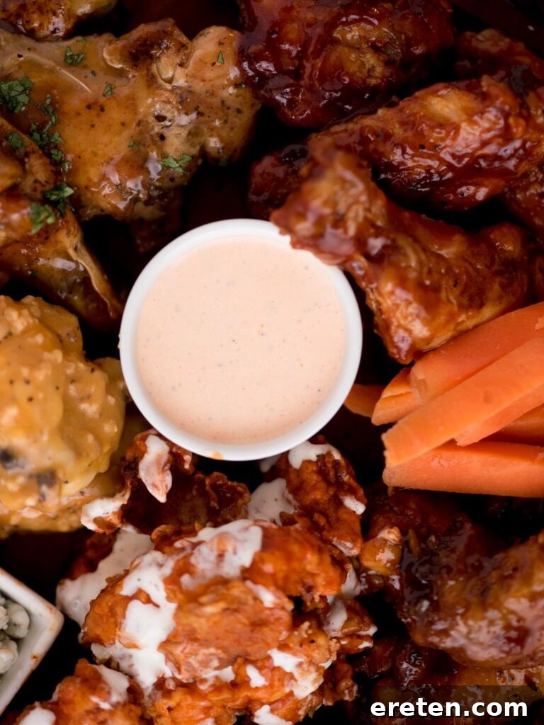 Bold Ranch Kick 7 A container of creamy buffalo ranch sauce surrounded by golden buffalo wings and crunchy carrot sticks, ready for dipping.