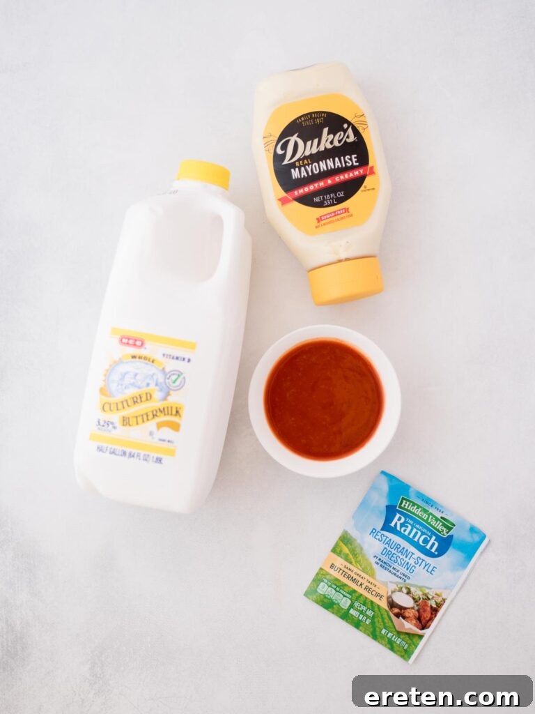 Bold Ranch Kick 3 A selection of fresh ingredients laid out, including buttermilk, mayonnaise, ranch seasoning mix, and a bottle of buffalo sauce, ready to make the sauce.
