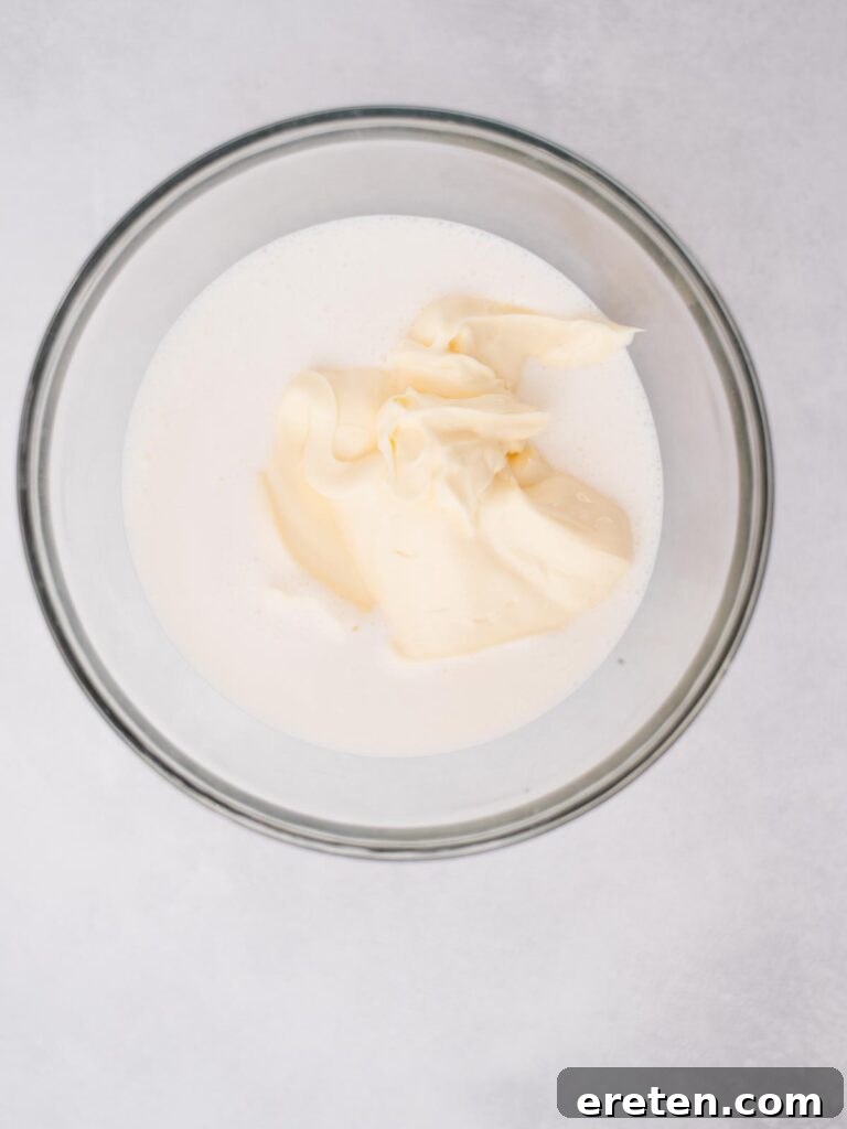 Bold Ranch Kick 4 Buttermilk and mayonnaise being added to a clean glass mixing bowl.